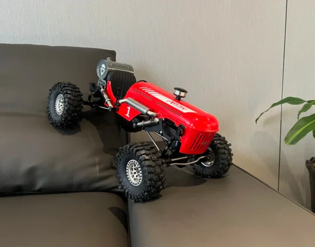 Original reference photograph of the red remote-controlled vehicle on a sofa
